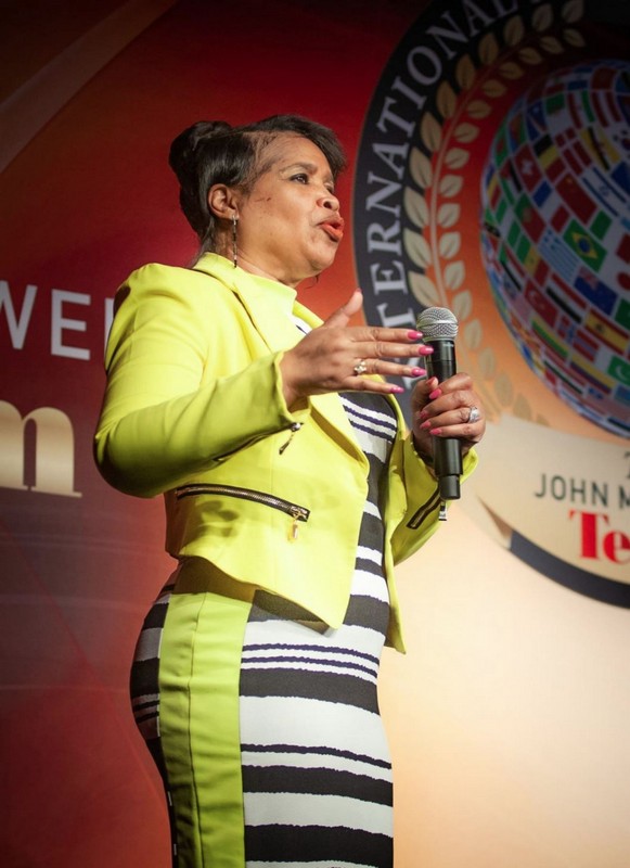 Deborah A Borges speaking wearing a yellow jacket